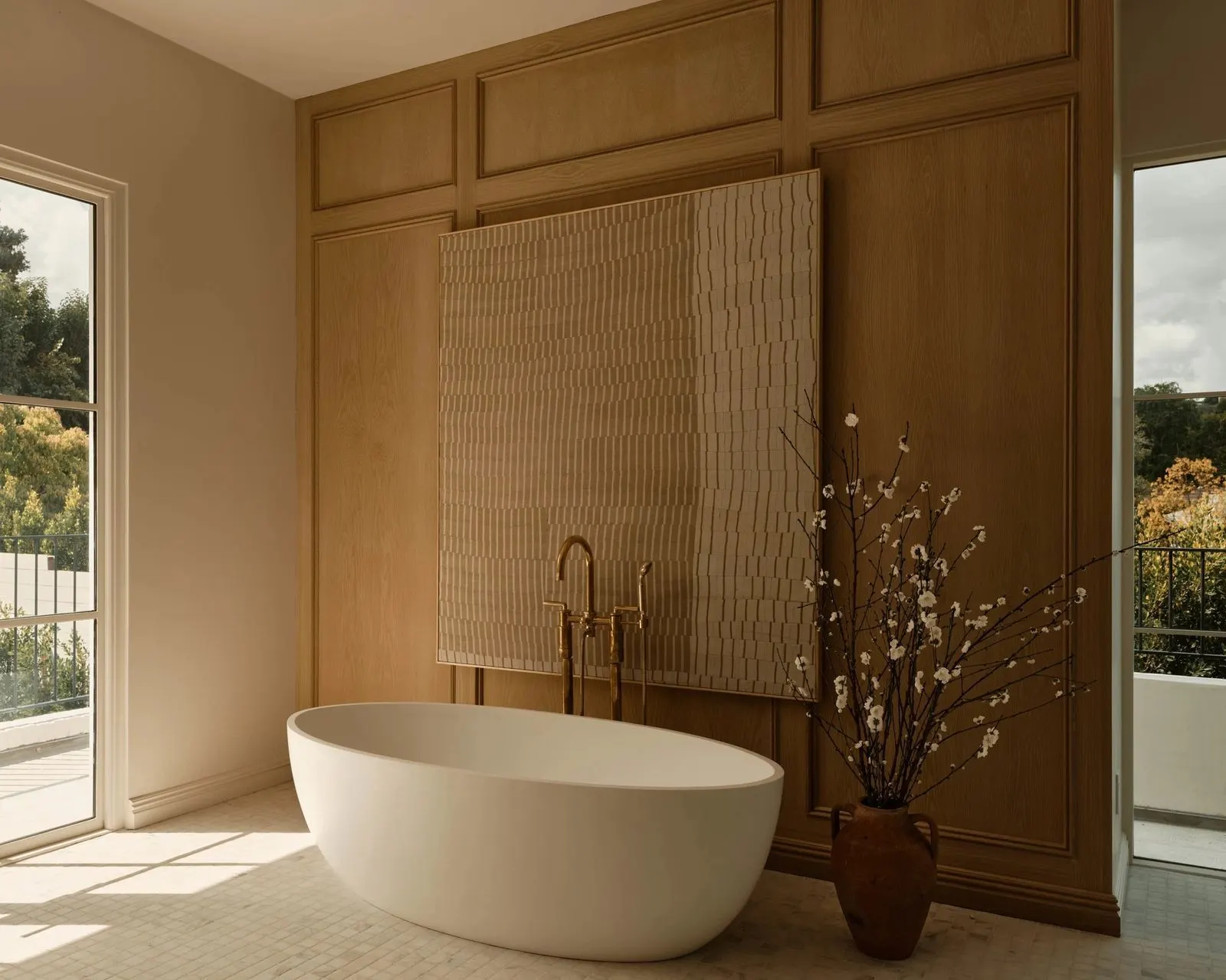 Bathroom with a freestanding tub before a large textured cream relief artwork on wood paneling