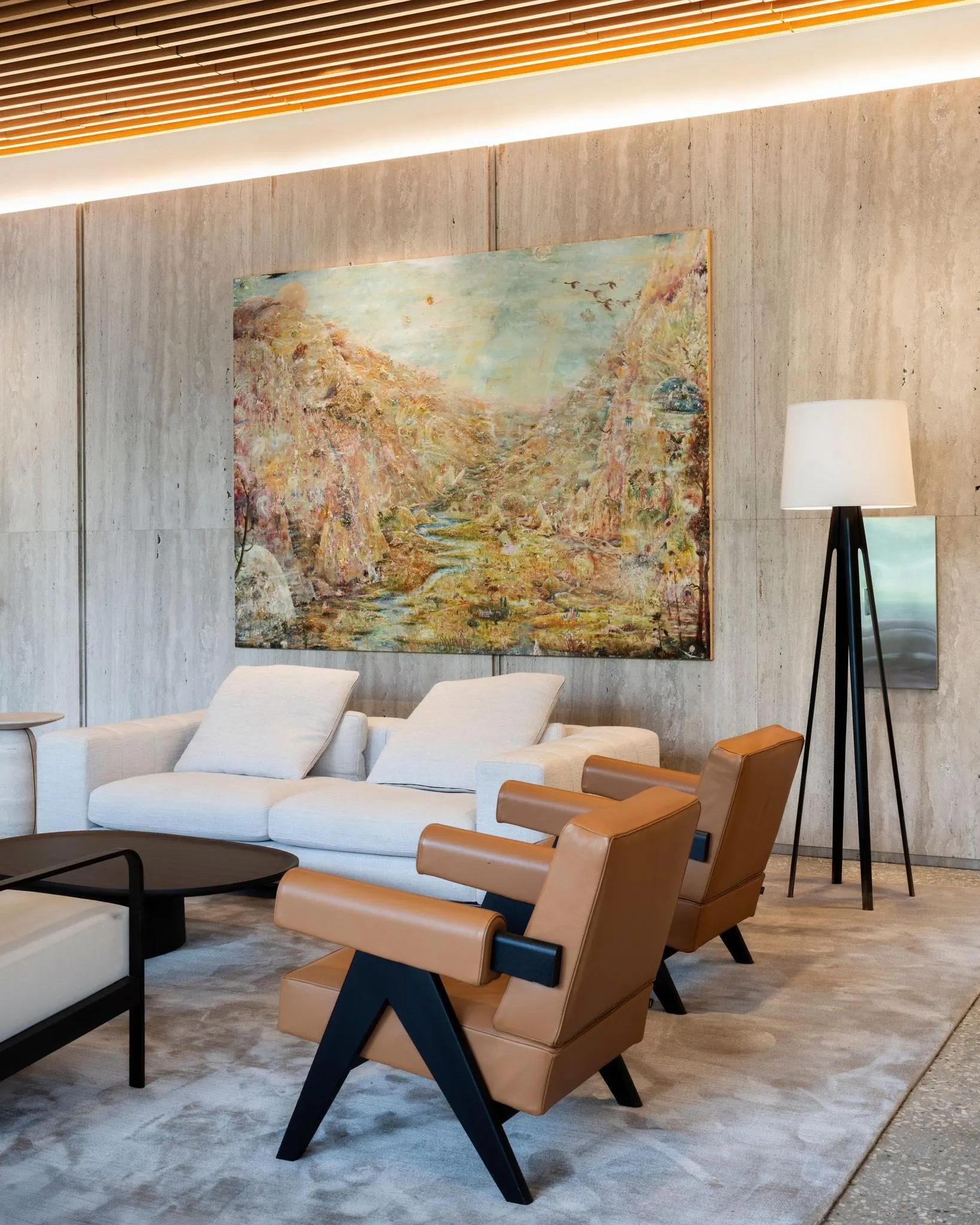 Large golden landscape painting above a white sofa in a lounge at Anderson Towers, artwork by Peter Burns