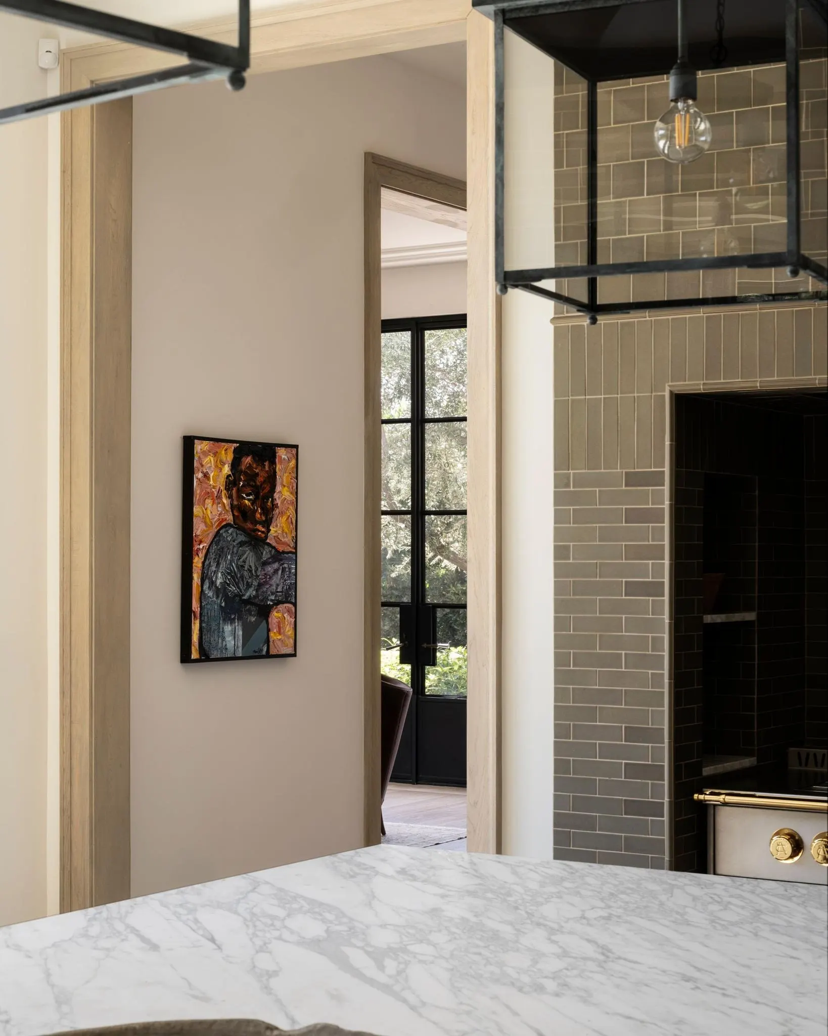 Framed portrait of a man on an orange background beside a marble kitchen island, artwork by Mario Joyce