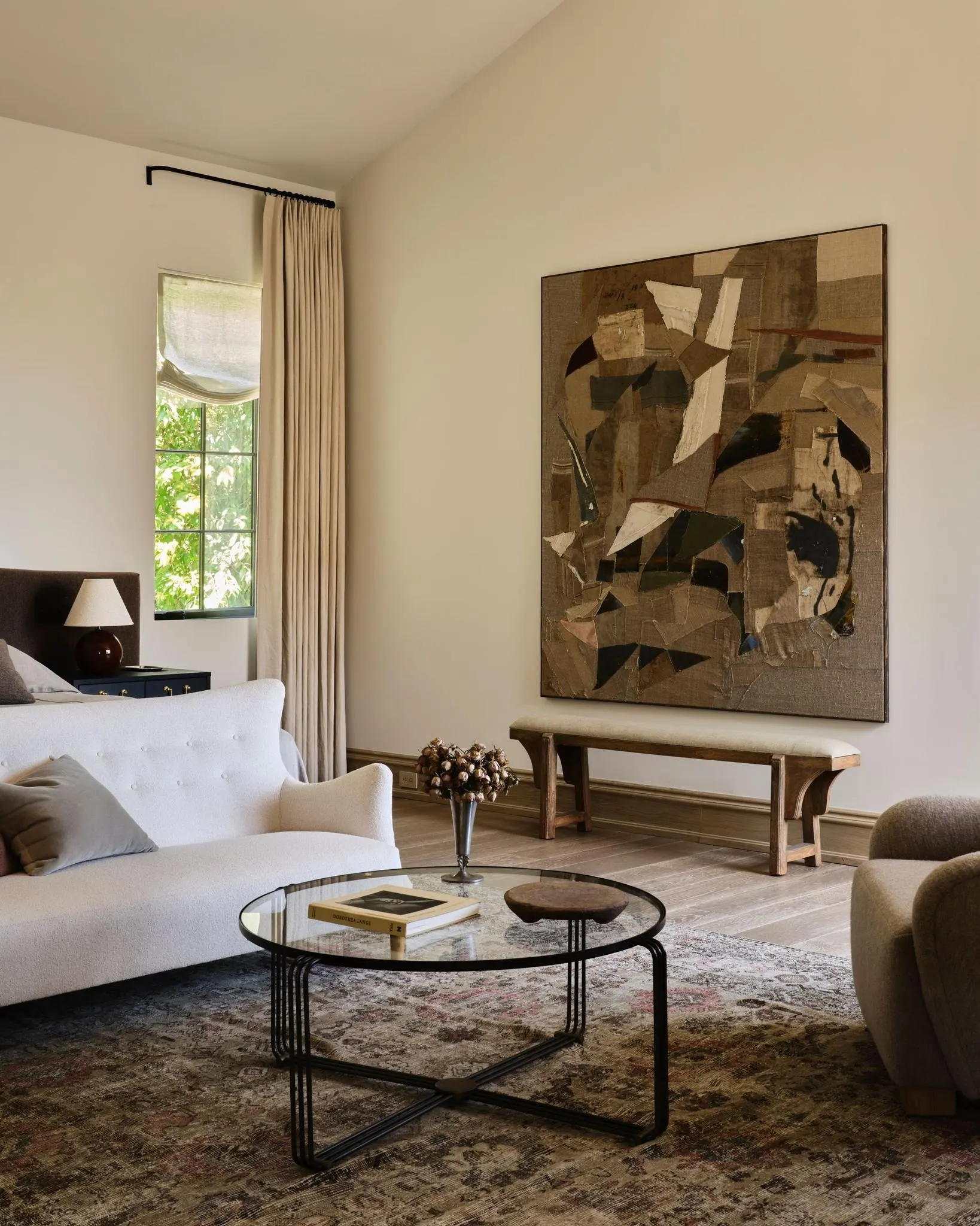 Large collage style painting in brown, black and cream above a bench in a living room, artwork by Lawrence Calver
