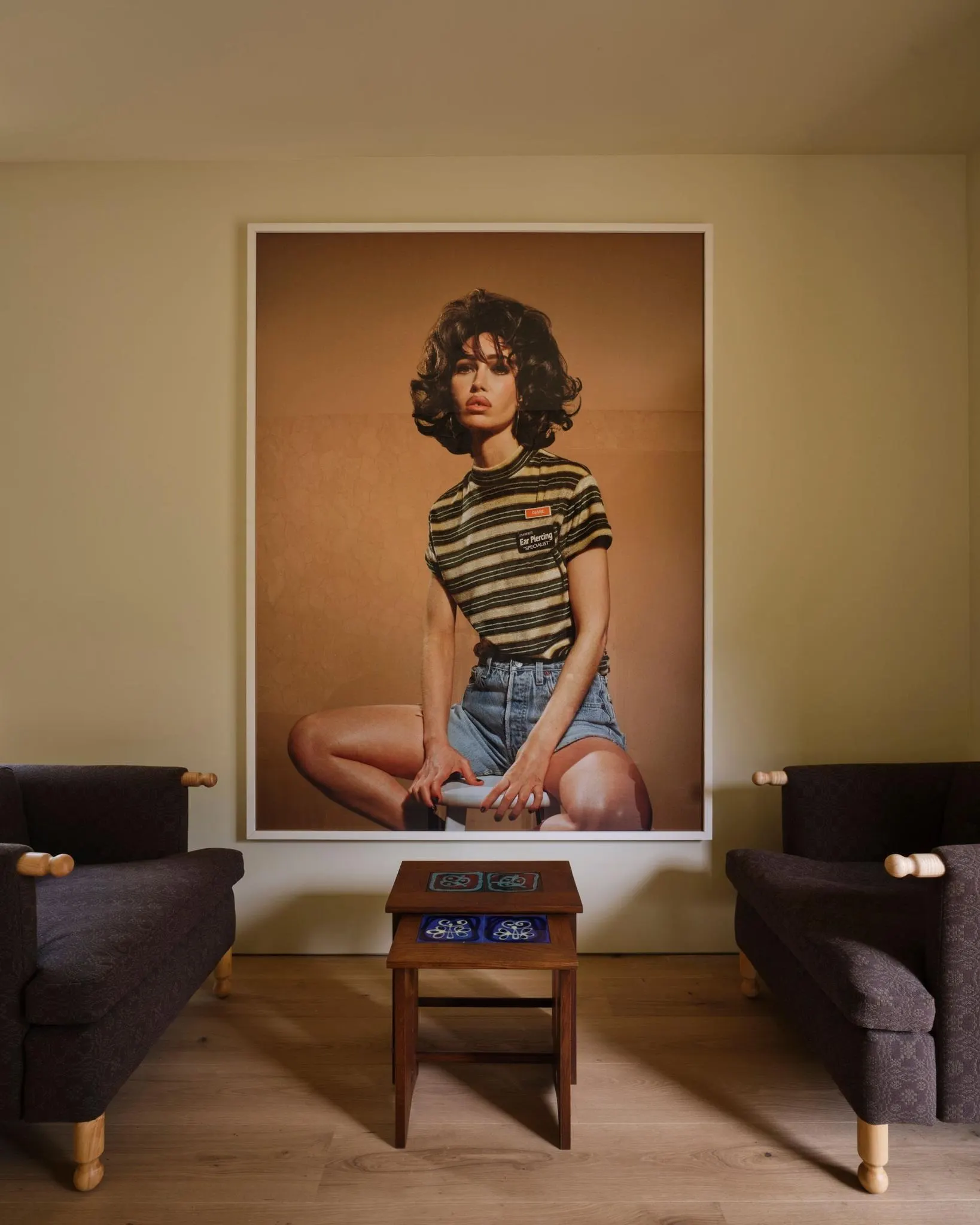 Sitting room in a Laurel Canyon residence with a large color photograph of a seated woman between dark armchairs