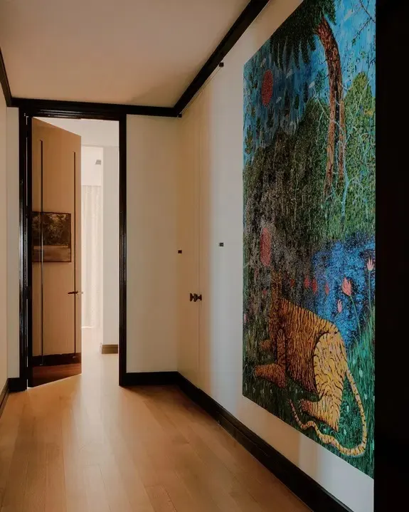 Hallway with a large colorful painting of a tiger in a lush jungle on a cream wall