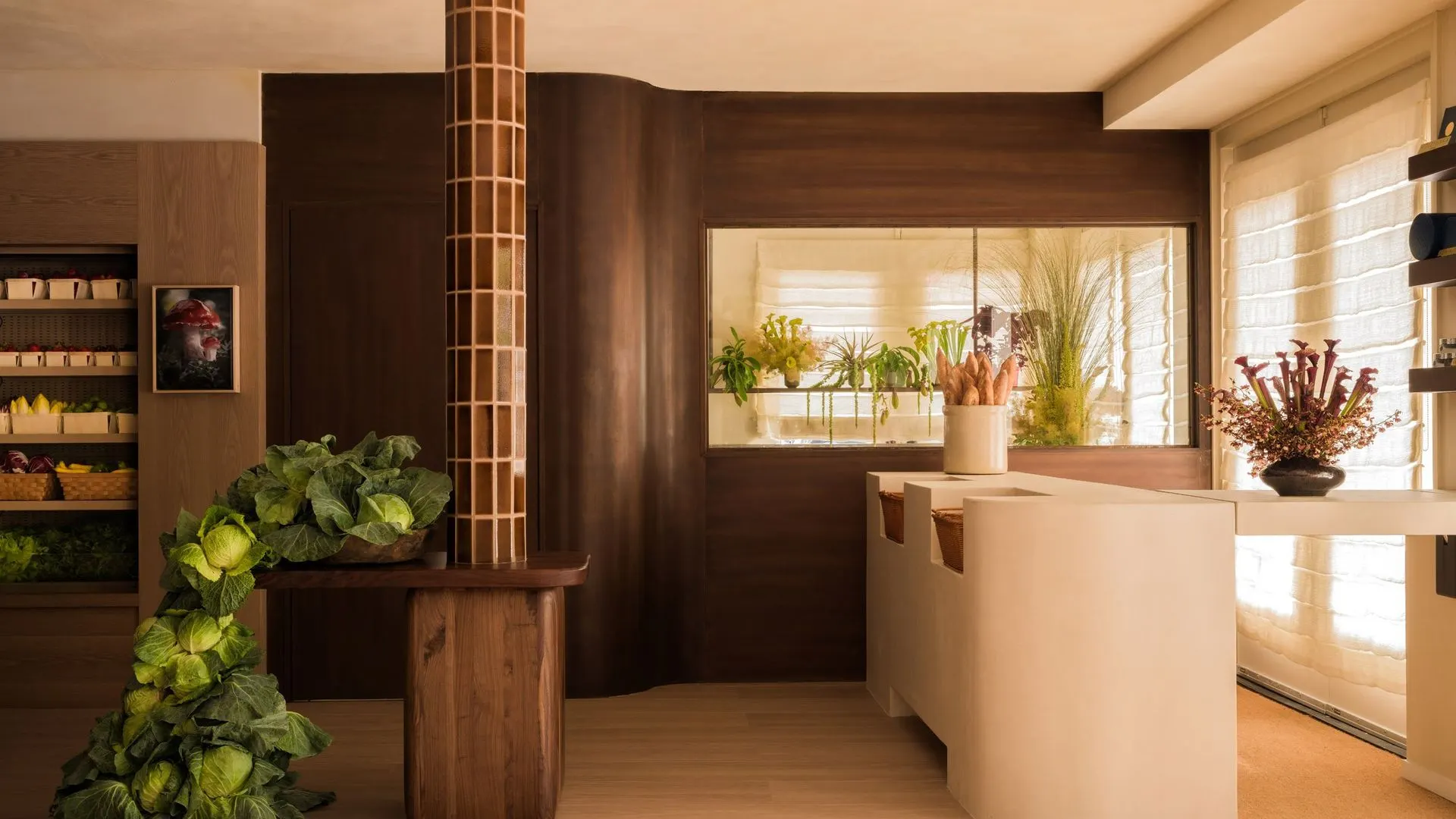 Grocery interior with curved walnut walls, a tiled column, produce display and a small framed portrait on the wall
