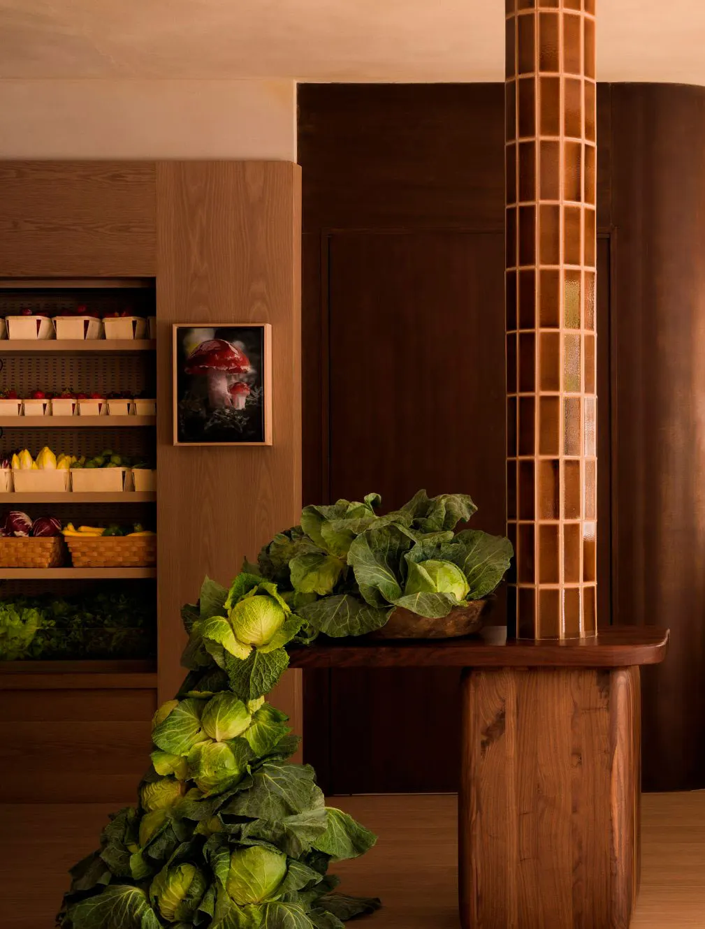 Specialty grocer with produce shelves, cabbages heaped on a wood counter and a small framed portrait