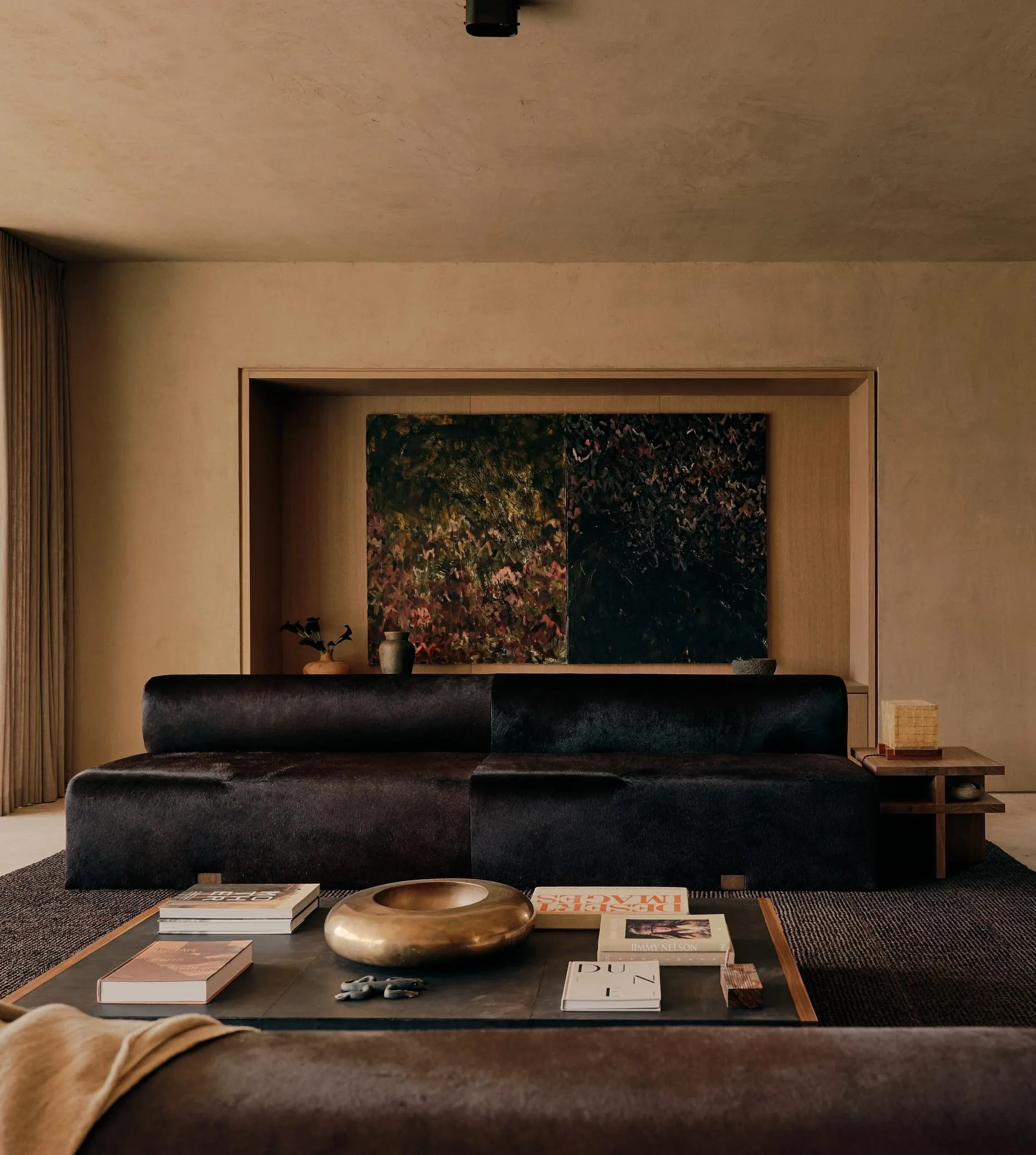 Dark floral abstract painting in a wood alcove above a black sofa in a living room, artwork by Gregory Arnold