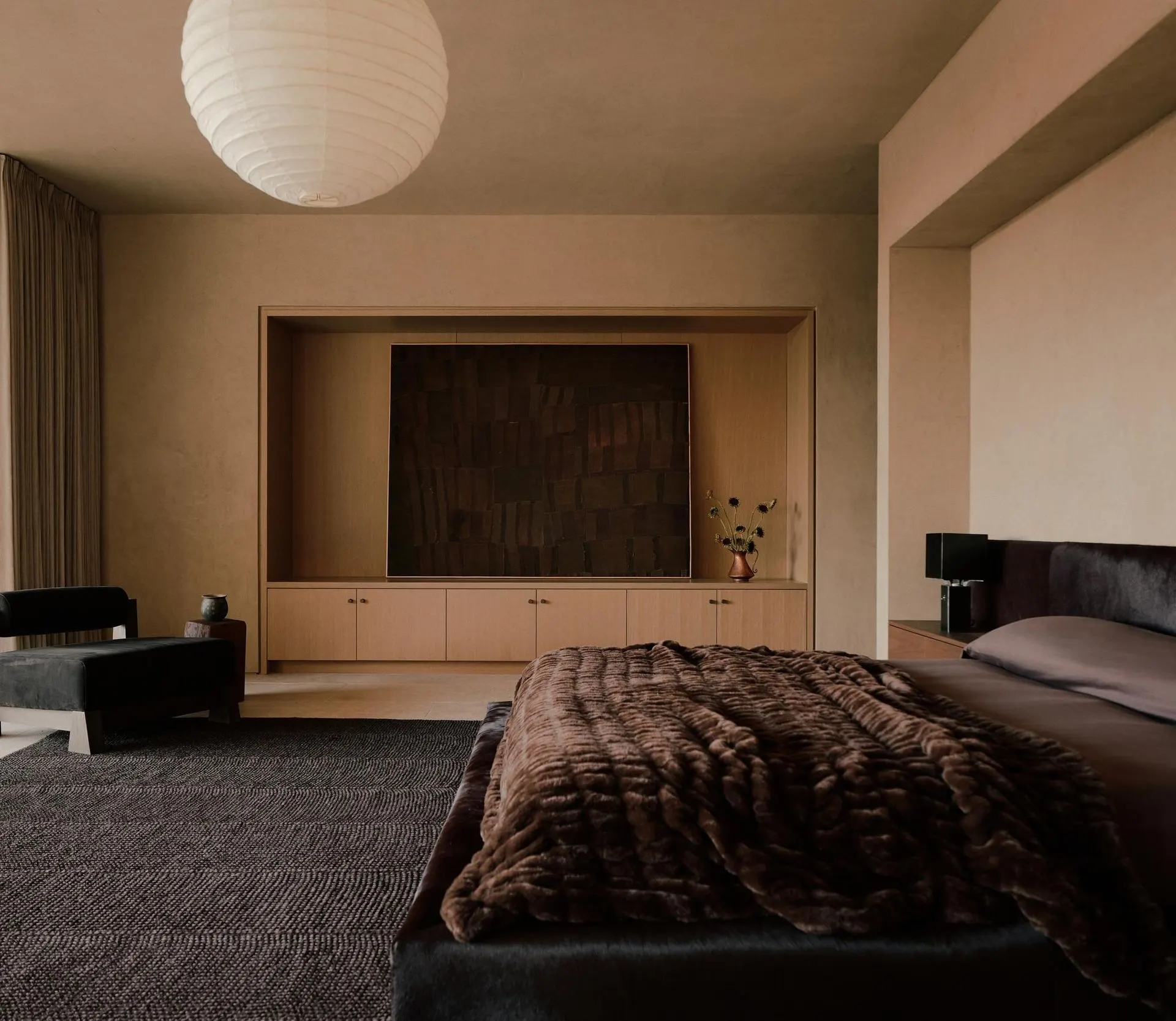 Dark textured wall piece set in a wood alcove of a bedroom with a paper lantern, artwork by Lawrence Calver