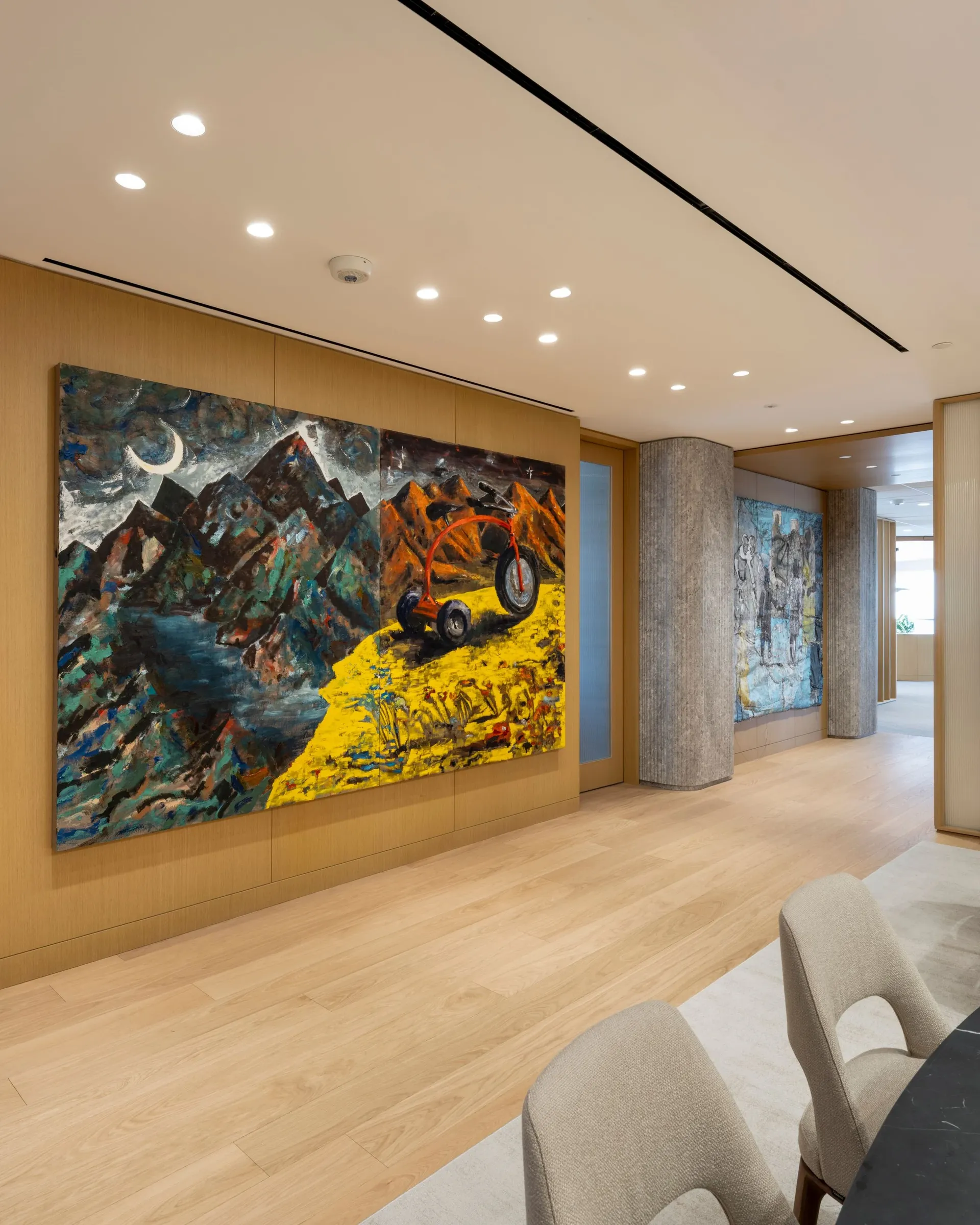 Large-scale paintings installed along a wood-paneled office corridor